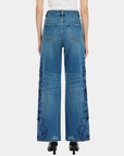 Back view of Bayeas high rise wide leg jeans in medium blue with tonal floral embroidery and cutout detailing.