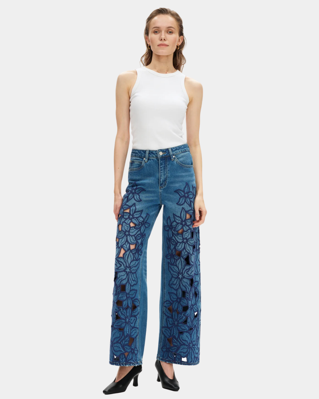 Model wearing Bayeas high rise wide leg jeans showing the medium blue wash and embroidered floral front detailing.