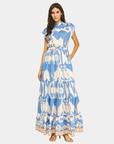 Model wearing a blue ikat print tiered maxi dress with a drawstring waist, front view.