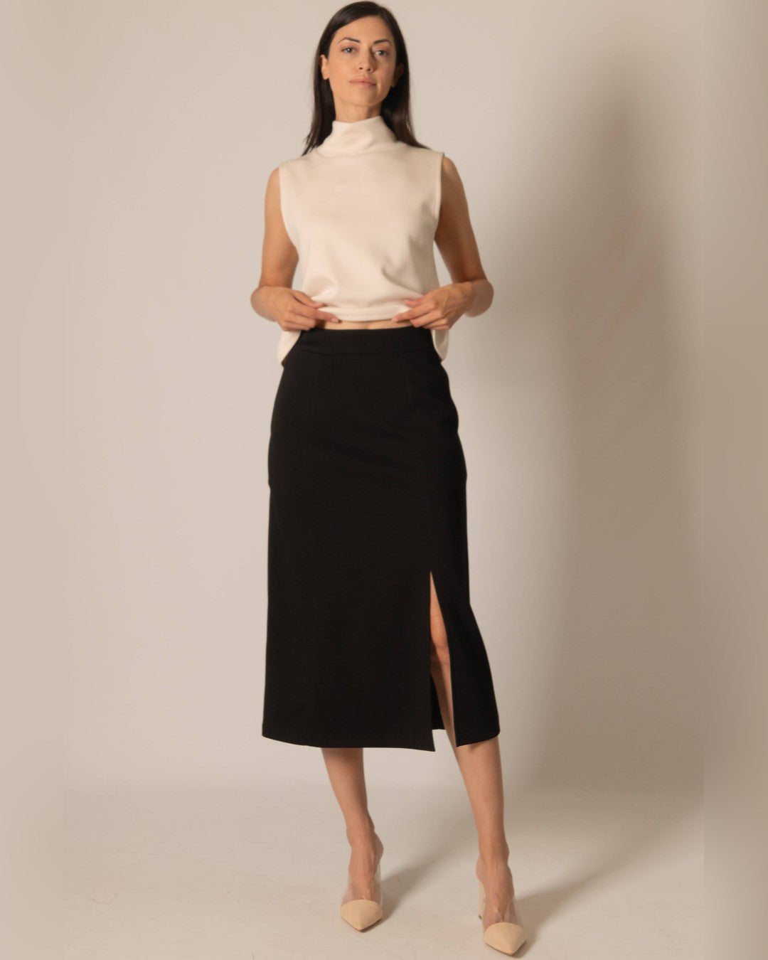 P.CILL Butter Modal midi skirt in black with a front slit, worn with an ivory sleeveless mock-neck top