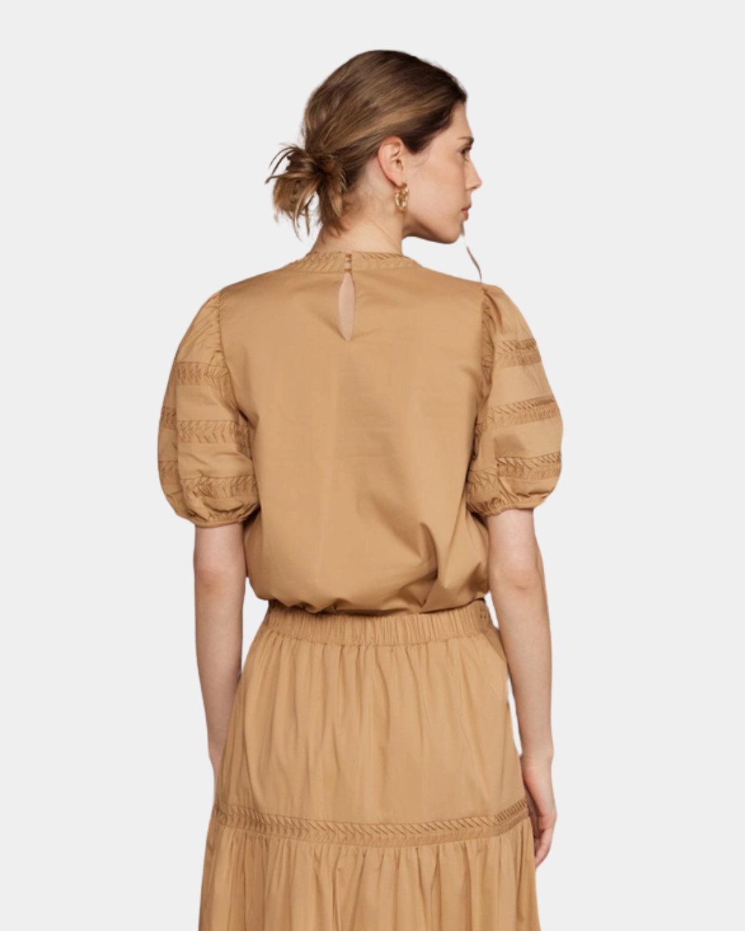 Back view of camel signature blouse with structured sleeves