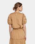 Back view of camel signature blouse with structured sleeves