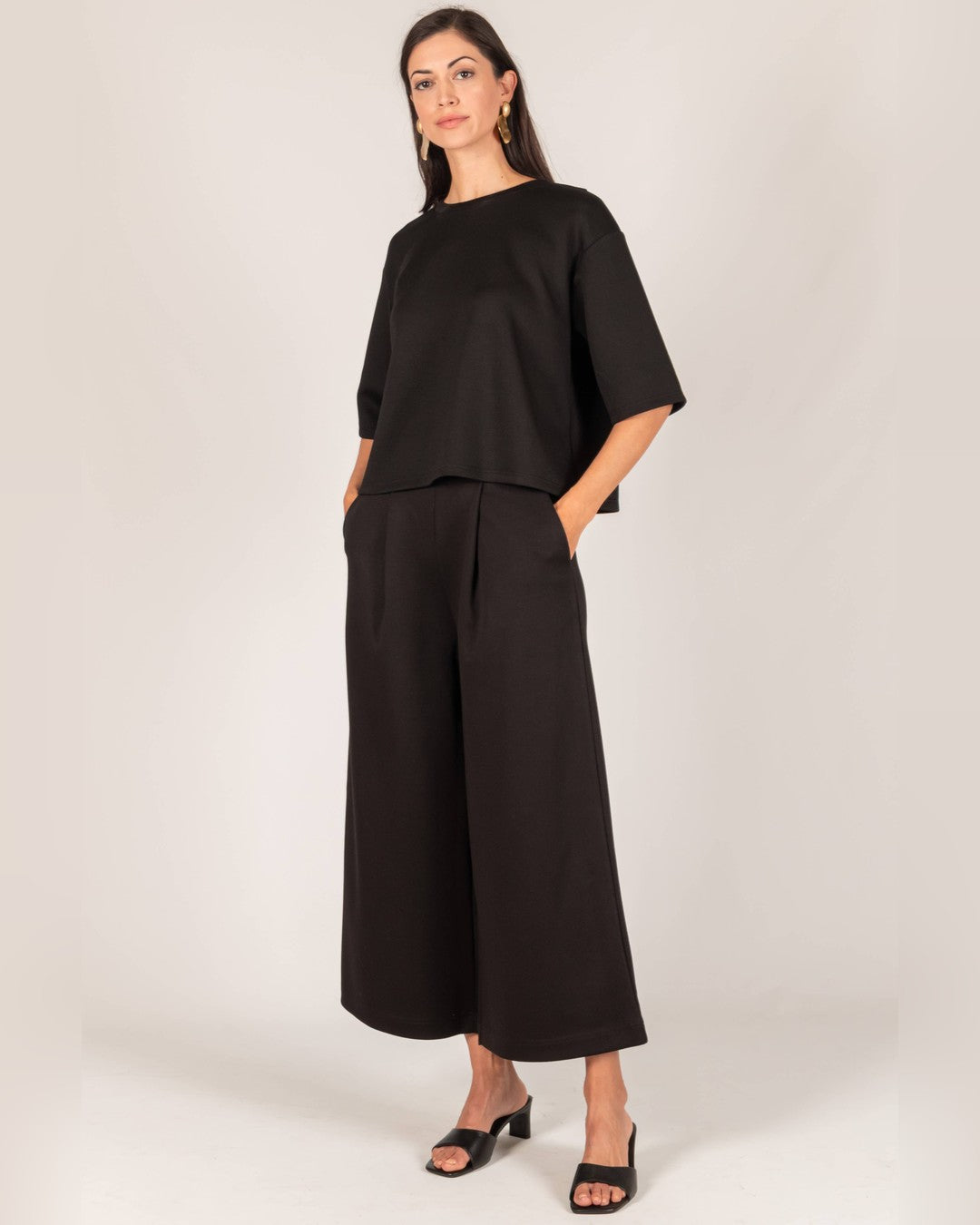 Full-length view of the black Hazel Overlap Back Top with cropped wide-leg pants and black sandals
