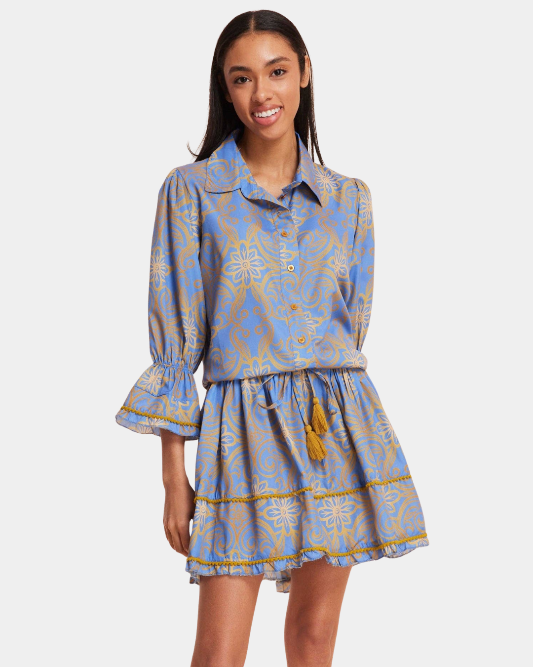 Angled front view of the Delphine Mini Dress in Blue & Gold with button front, tie waist and flared sleeves