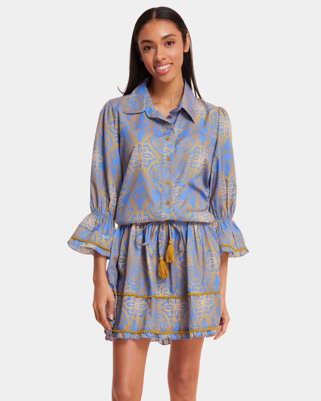Front view of the Delphine Mini Dress in Blue & Gold featuring a button front, tassel tie waist and tiered skirt