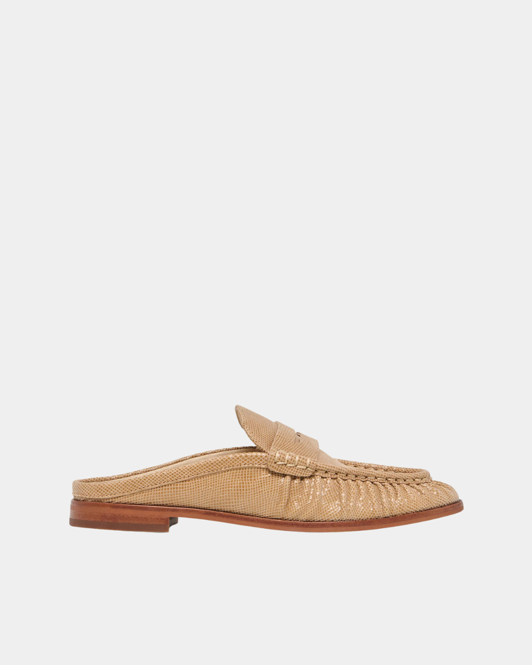 Side profile of the Dolce Vita Betzy Loafers in crème embossed suede featuring a backless mule silhouette, ruched moc toe, and classic penny loafer styling.