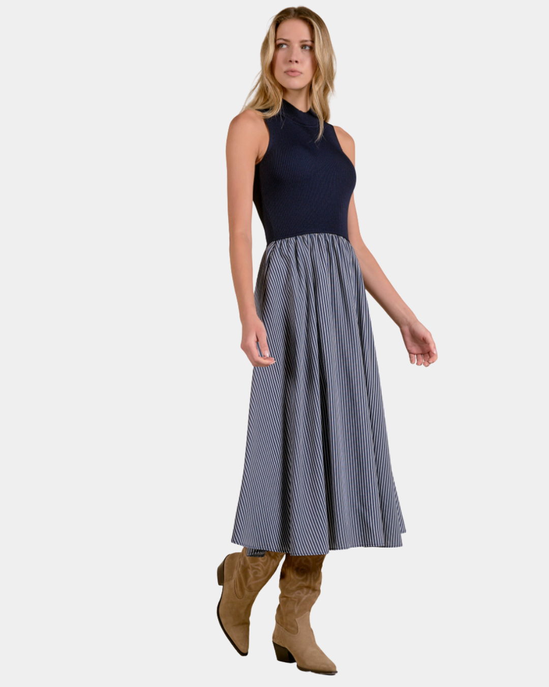 Model wearing the Elan Harlow mixed media midi dress in Blue Stripe styled with suede boots.