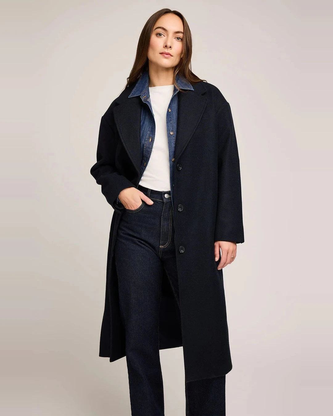 Front view of the navy Agatha Coat worn open with notched lapels over a denim shirt and white tee