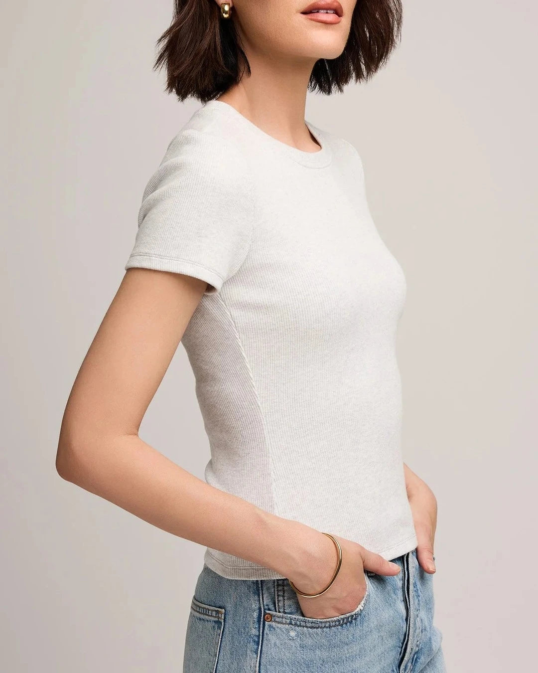Side view of the Gentle Fawn Ribbed Tate Tee in light heather grey with light wash jeans