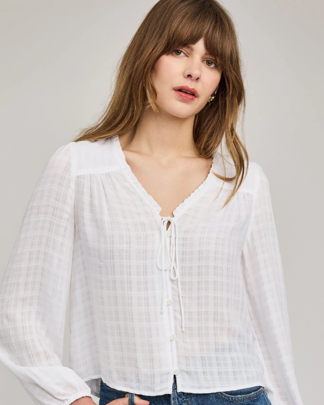 Front view of the Gentle Fawn Vanessa Blouse in white sheer check with a tie front and ruffled V-neck