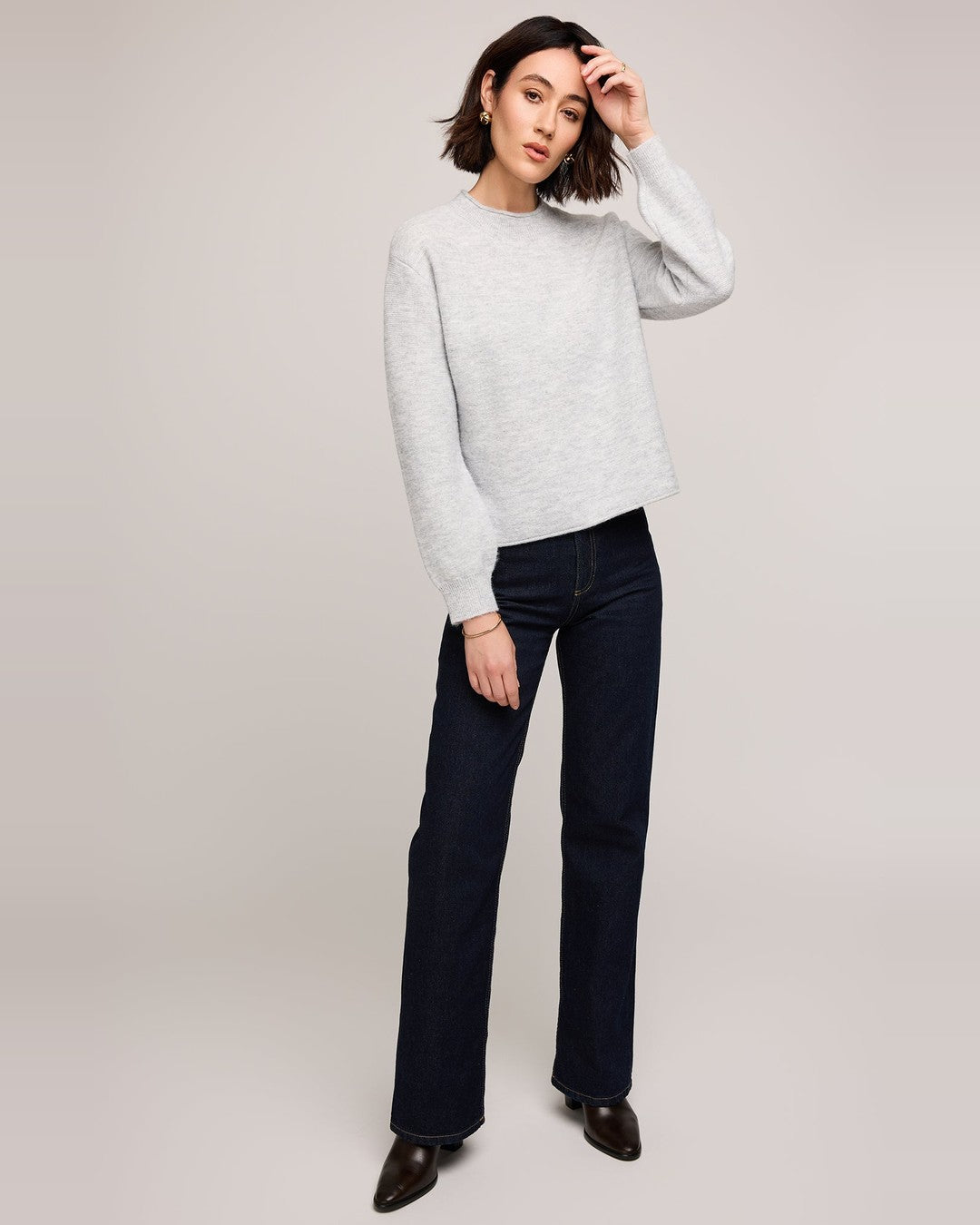 Full-length view of the heather grey Wanda pullover with dark wide-leg jeans and black ankle boots