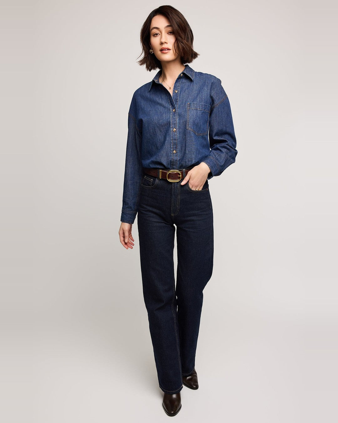 Full-length view of the Whitney dark wash denim shirt tucked into straight-leg jeans with brown ankle boots