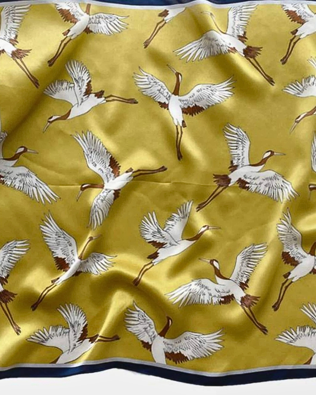 Golden crane mulberry silk scarf flat lay showing elegant crane motif