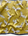 Golden crane mulberry silk scarf flat lay showing elegant crane motif