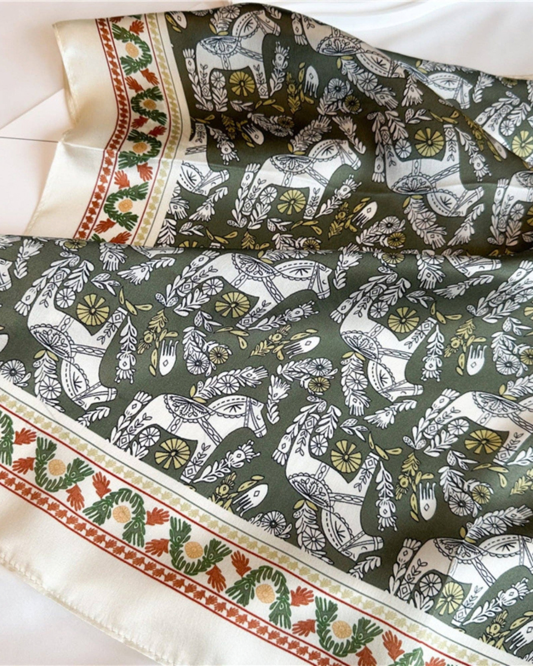 Full view of the Greek Horse Mulberry Silk Scarf showing the olive equestrian print and ivory border
