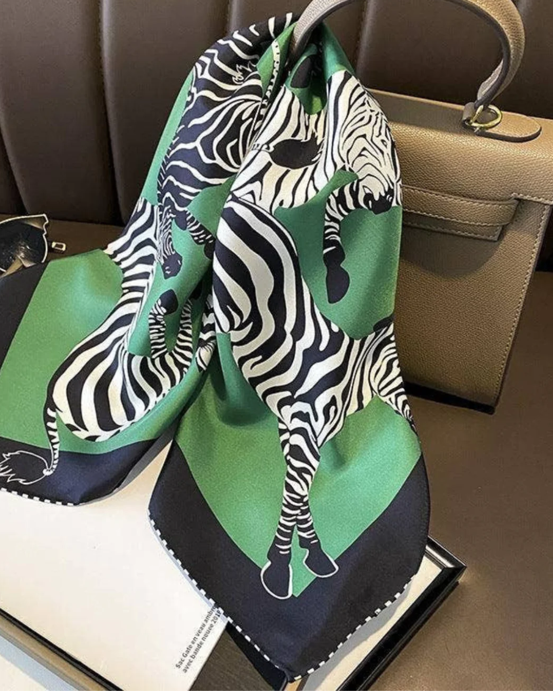 Green zebra print silk scarf tied on handbag as accessory