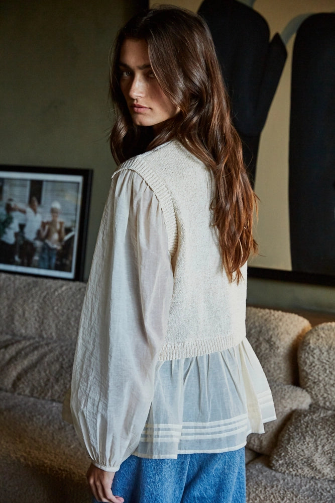 Detail of soft knit overlay on layered cream blouse