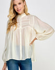 Ivory sheer blouse styled with denim jeans for an elevated casual look
