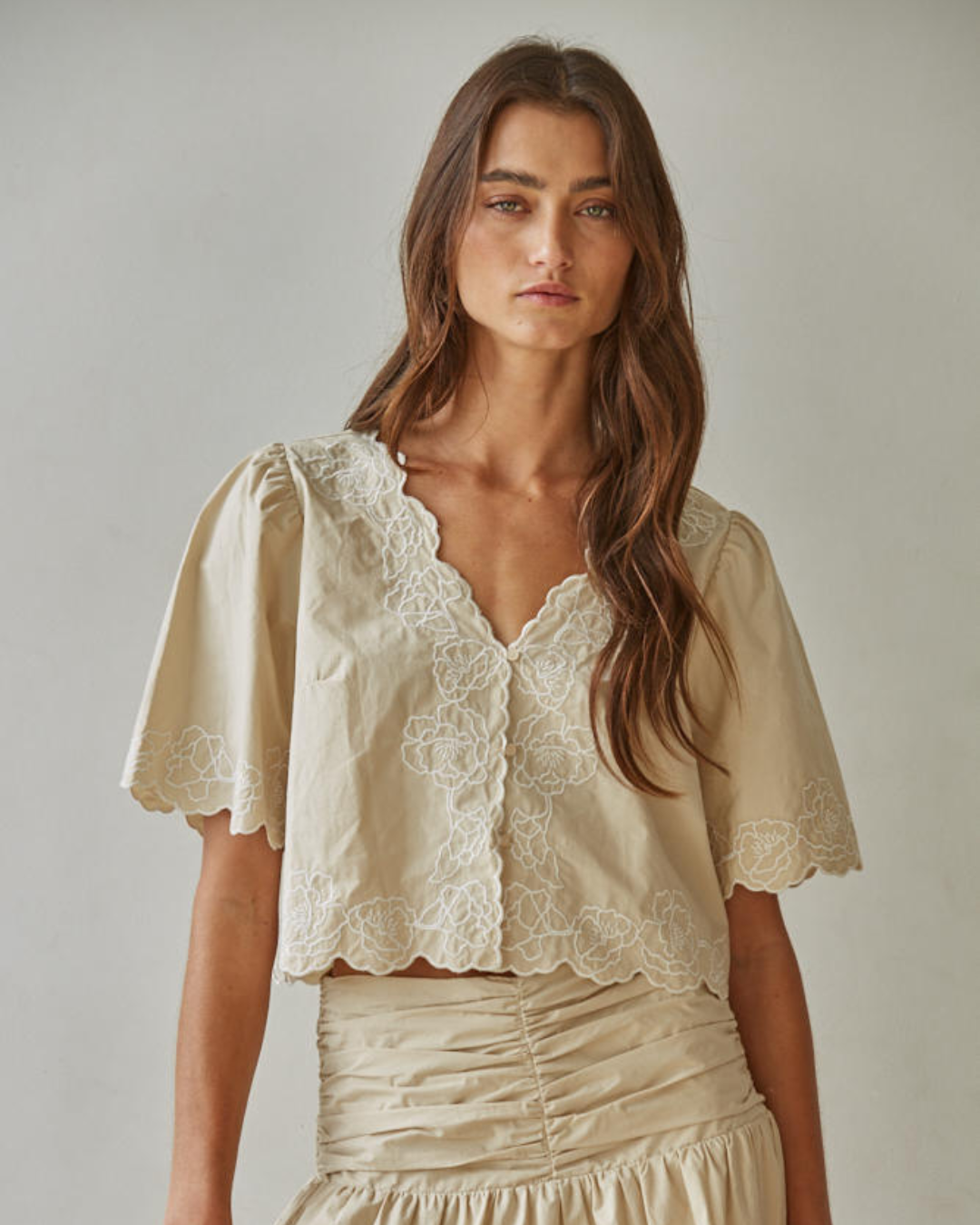 Close-up detail of the tonal embroidery on the cotton fabric of the Maison puff sleeve blouse.