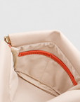 Montemare Roma Square Pouch in Ivory, interior view with orange trim and interior pocket.