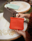 Montemare Roma Square Pouch in Orange shown in a lifestyle setting.