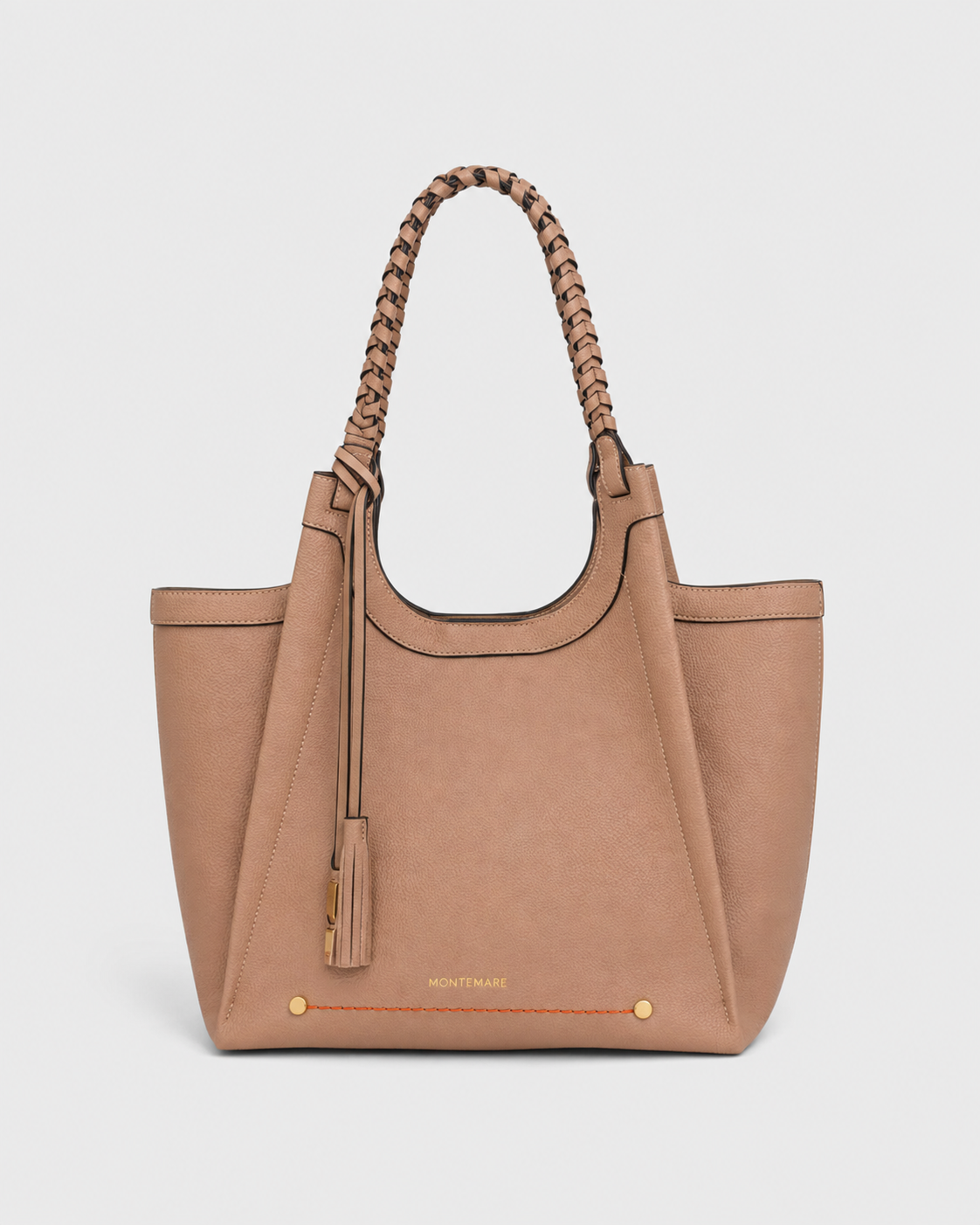 Montemare Sedona Tote in Latte shown from an angled view with braided handles, tassel detail, gold hardware and orange accent stitching.