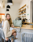 Montemare Vienna Small Carry On Tote in Blakes Blue styled in a cafe lifestyle setting