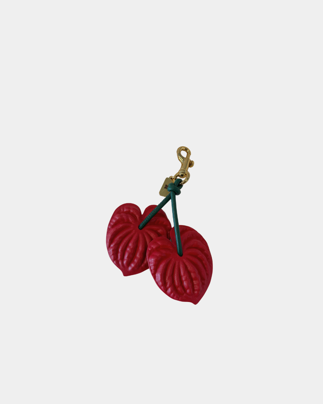 Close-up of Oceans End anthurium bag charm showing textured red floral detail