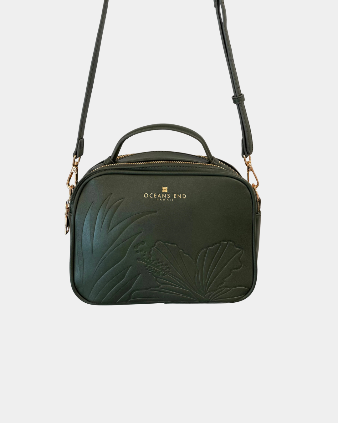 Oceans End Justine 2.0 crossbody bag in emerald featuring an embossed hibiscus design, top handle, adjustable crossbody strap, and gold-tone hardware.