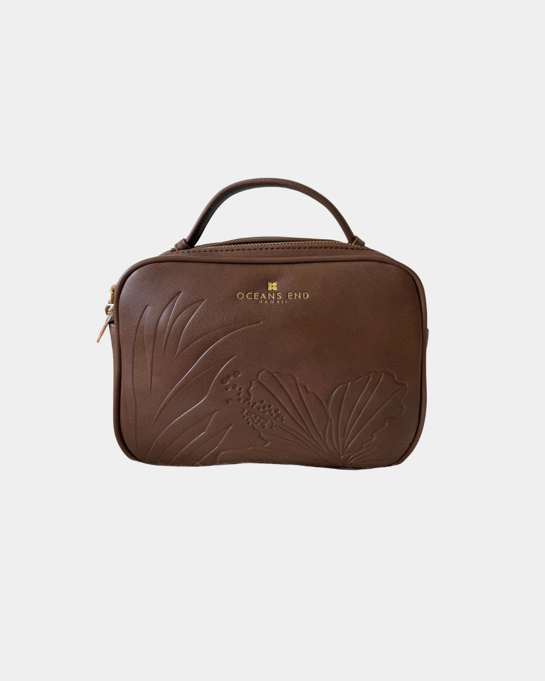 Front view of the Oceans End Justine 2.0 mocha crossbody handbag showcasing the embossed tropical hibiscus artwork and structured silhouette.