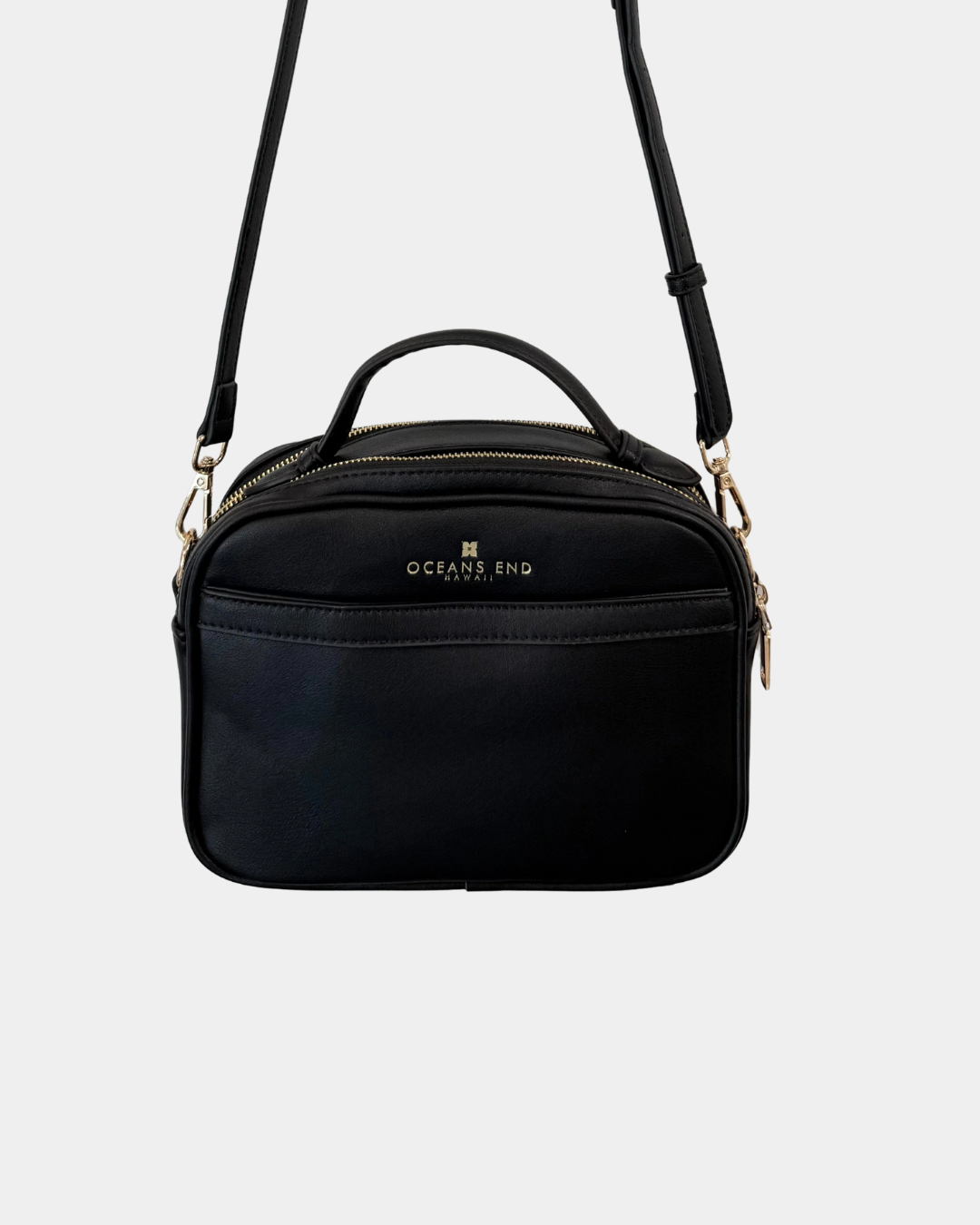 Back view of the Oceans End Justine 2.0 onyx crossbody bag featuring a convenient exterior slip pocket, top handle, and adjustable shoulder strap.