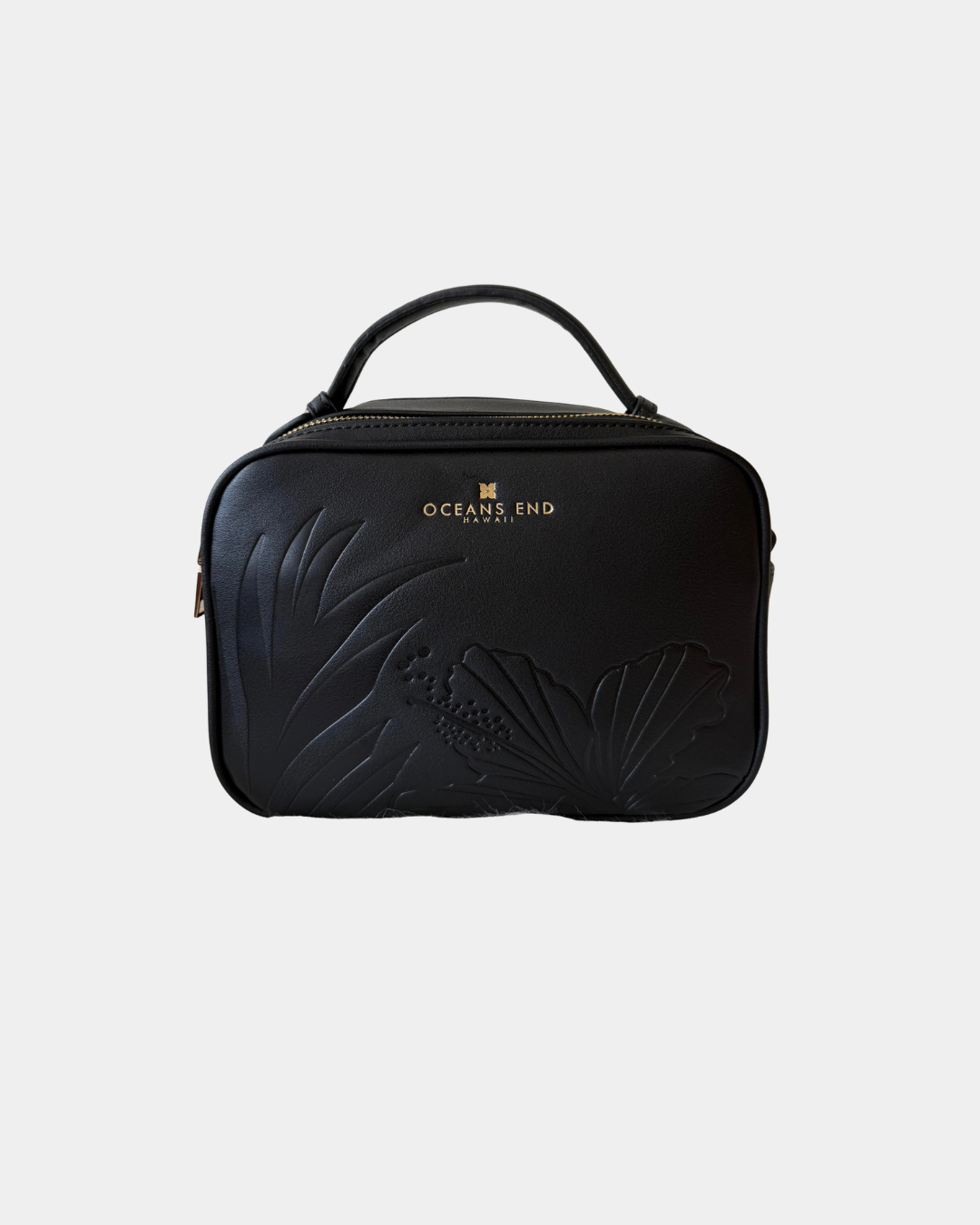 Front view of the Oceans End Justine 2.0 onyx crossbody handbag showcasing the embossed tropical hibiscus artwork and structured silhouette.