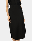 Detail view of the P.CILL Diana Butter Modal Midi Skirt in Black showing the curved hem and side slit