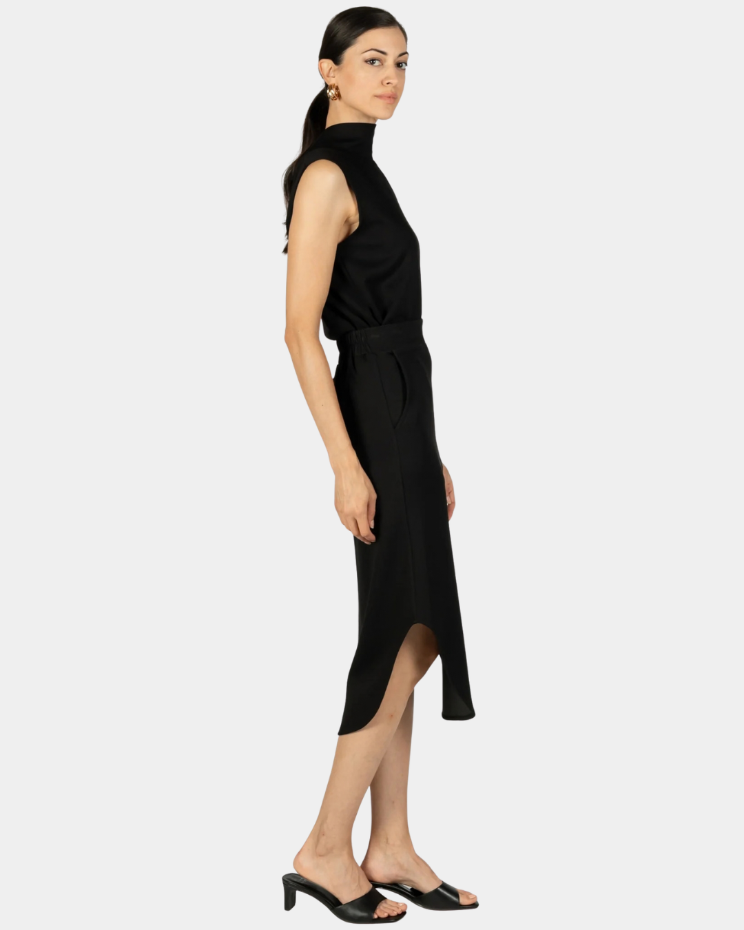 Side view of the P.CILL Diana Butter Modal Midi Skirt in Black showing the side slit and curved hem