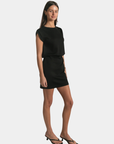 Side view of the P.CILL Kai Butter Modal Mini Dress in Black styled on model