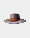 Close-up of the embroidered detailing and feather accent on the Camaleon hat.