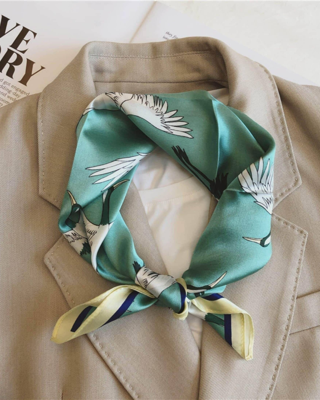 Sea green crane mulberry silk scarf styled around the neck