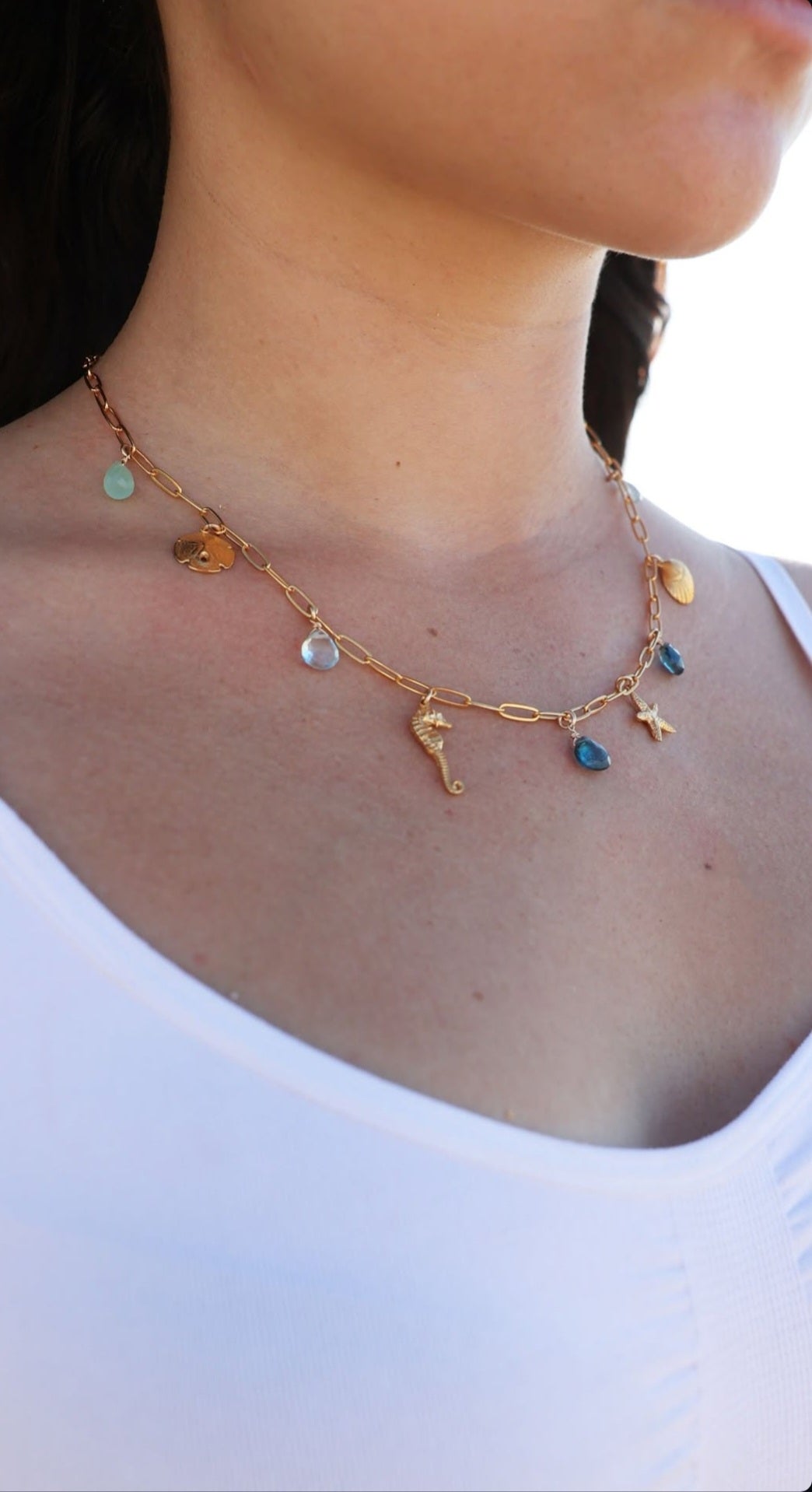 Handcrafted sealife charm necklace inspired by ocean symbols on model