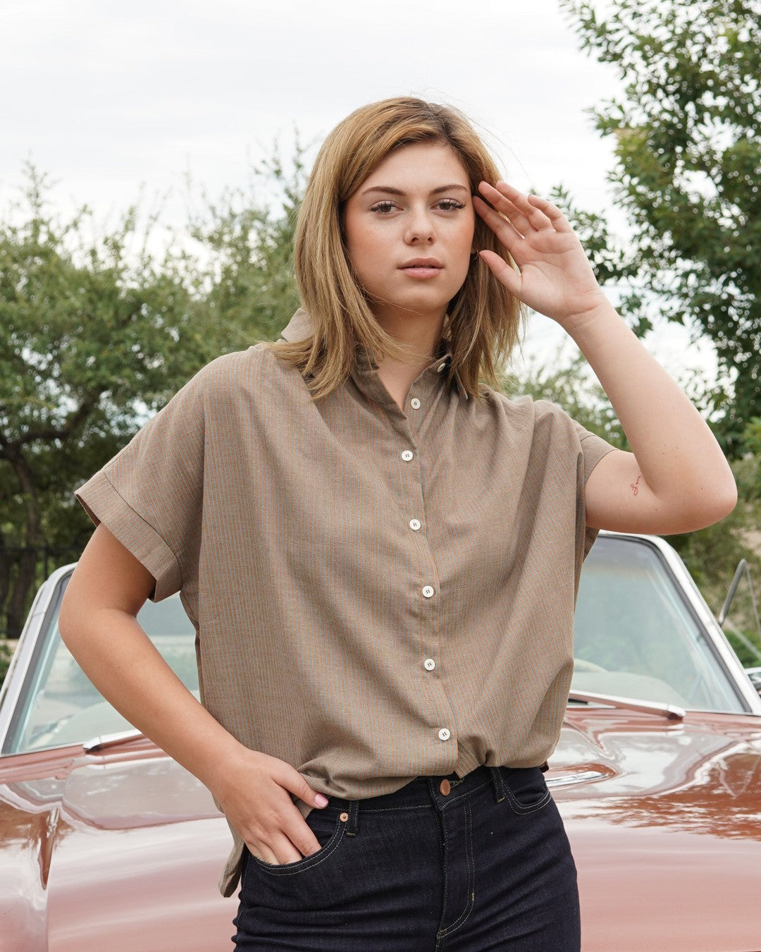 Mocha Pin Stripe Button Down with cuffed short sleeves, worn with dark jeans in front of a vintage convertible