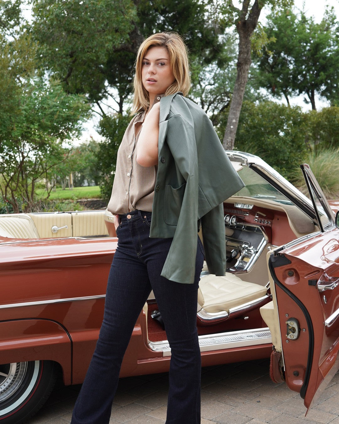 Pin Stripe Button Down styled with dark flare jeans, strappy sandals and a green leather jacket over one shoulder